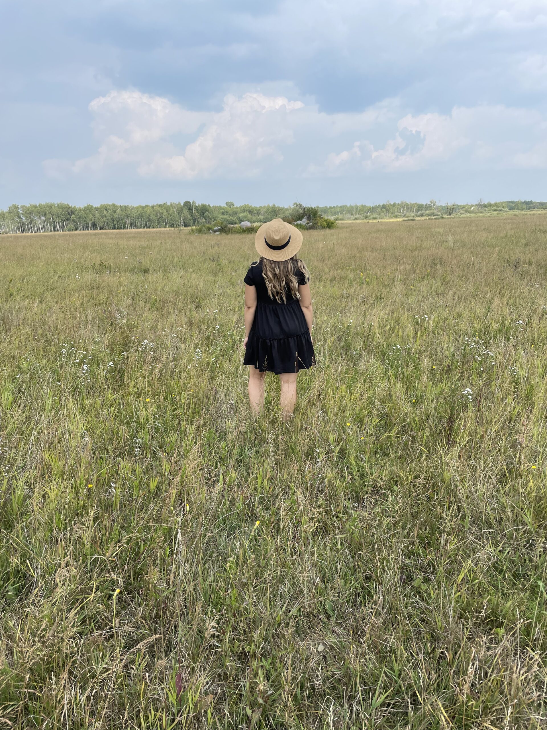 Mother behind Lady Slipper Homestead looking away in field