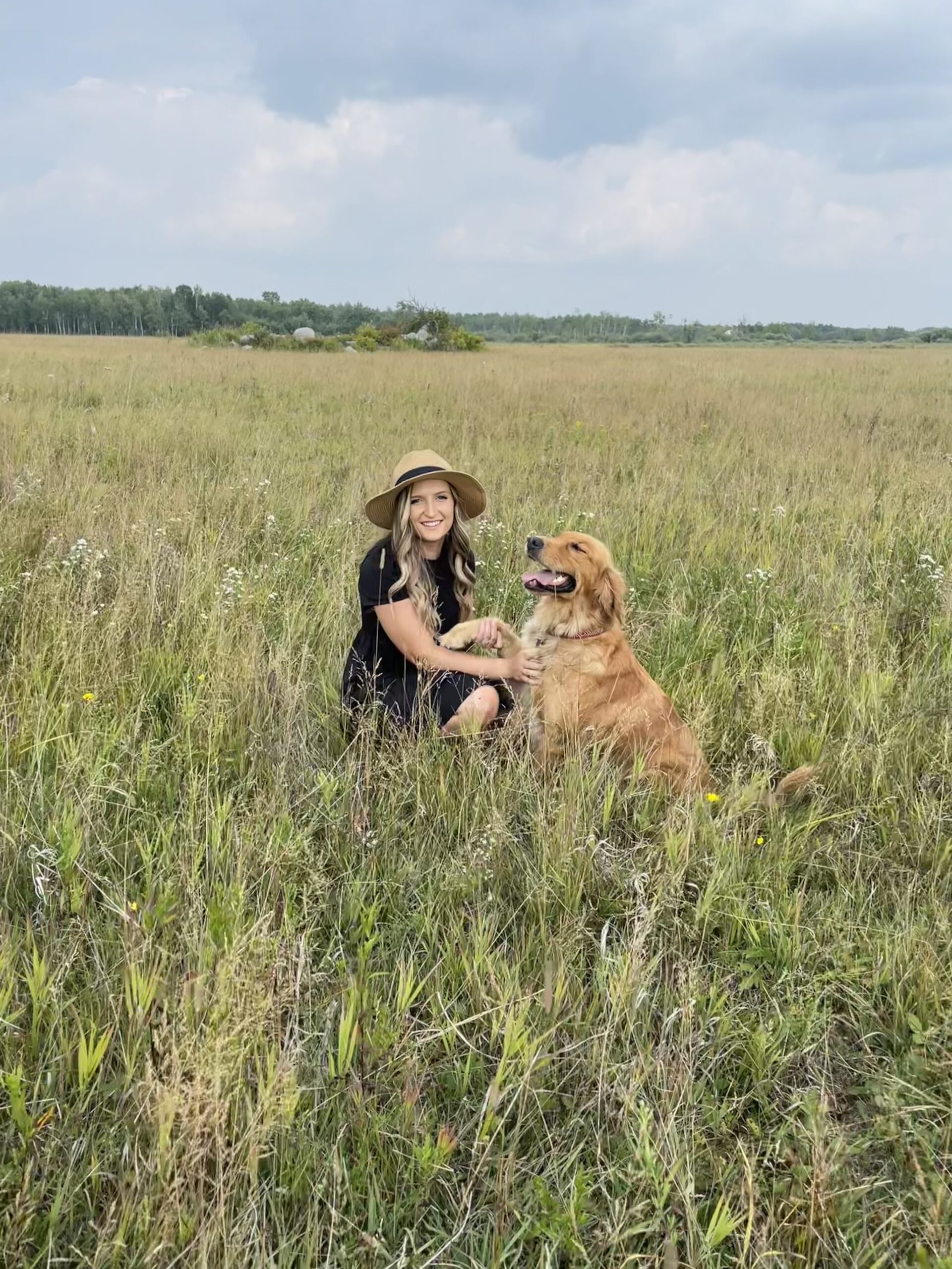 Mother behind Lady Slipper Homestead with dog in field looking